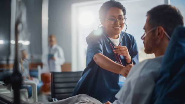 Hospital Ward: Friendly Nurse Uses Stethoscope to Listen to Heart, after a Heart-on-a-chip surgery.