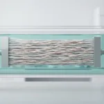 Transparent bioreactor chamber holding an aligned electrospun tendon scaffold with elongated cells oriented along the fibre direction, illustrating mechanical stimulation in tendon tissue engineering in a research lab.